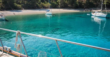 Datça Domuz Çukuru koyunda teknede şarap keyfi ve turkuaz deniz manzarası.